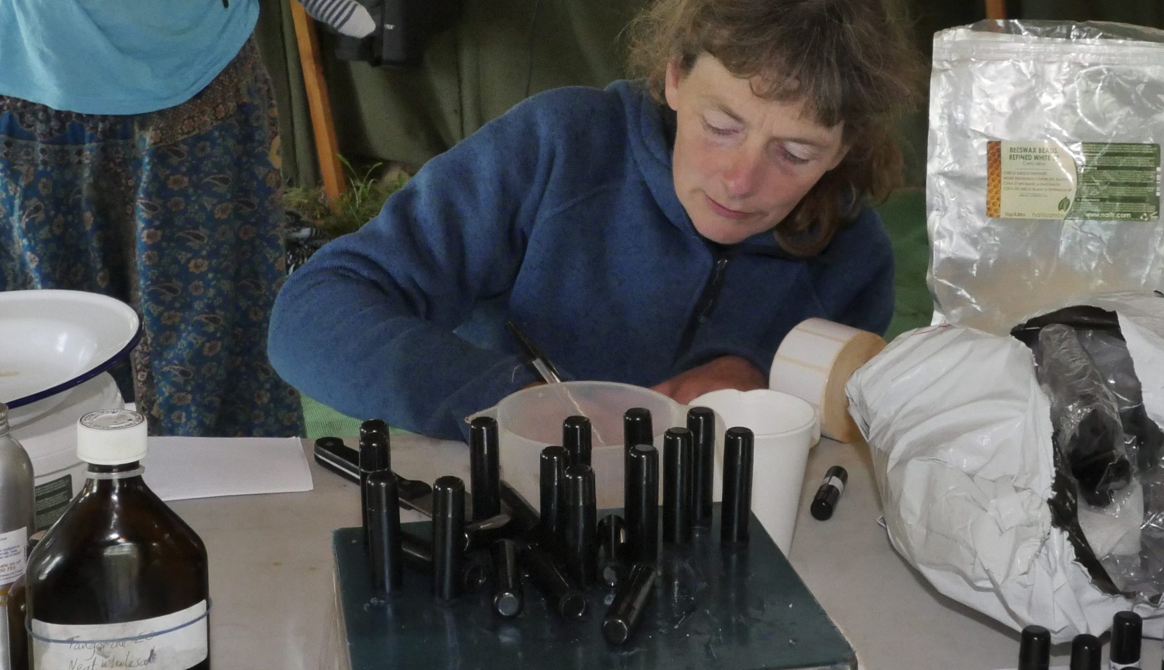 iain stewarts workshop a woman labels and weighs small bottles