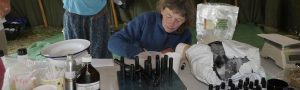 iain stewarts workshop a woman labels and weighs small bottles