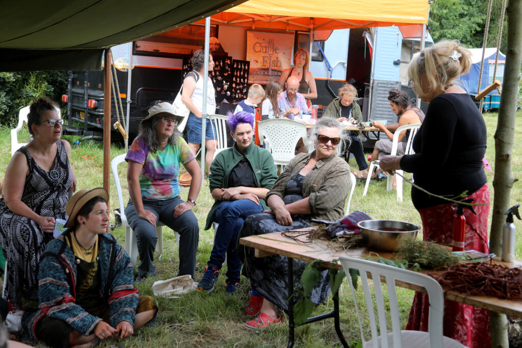 People enjoying practical workshops in small marquees in a beautiful field.