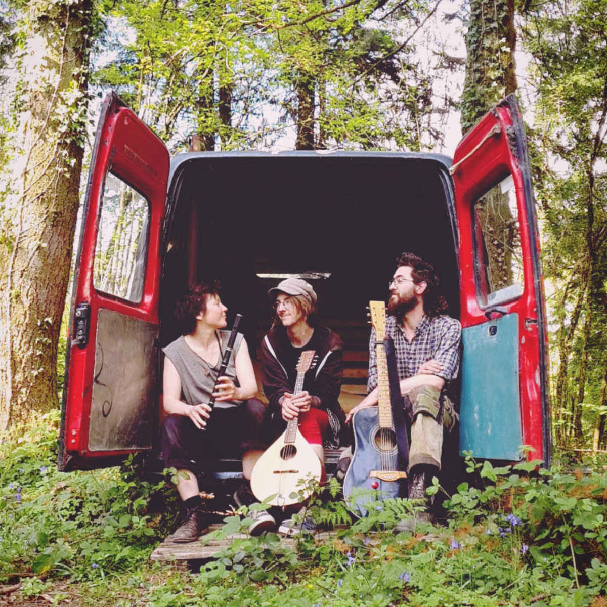Beggar's Buttons band sitting in the open back doors of an old van.